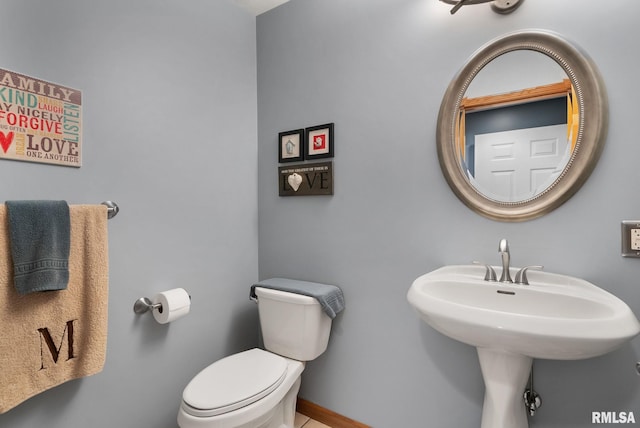 bathroom with baseboards and toilet