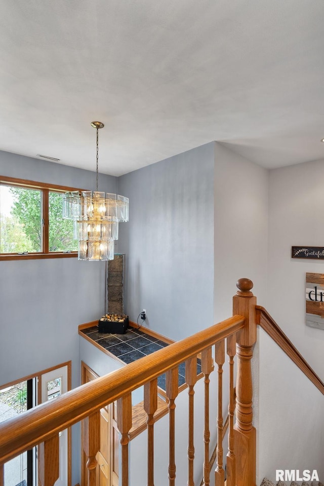 stairs with visible vents and a chandelier