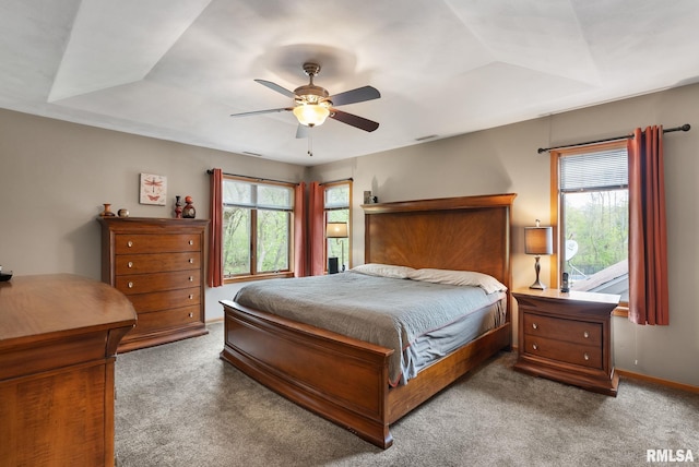 bedroom featuring baseboards, carpet flooring, ceiling fan, and multiple windows