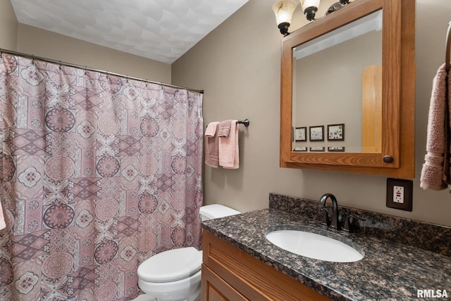 bathroom with toilet, curtained shower, and vanity