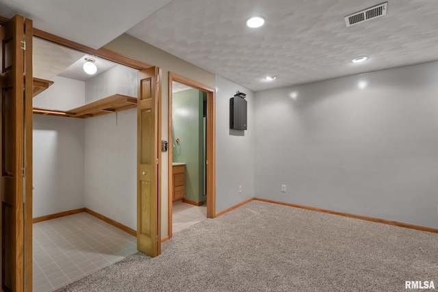 finished below grade area featuring recessed lighting, baseboards, visible vents, and carpet