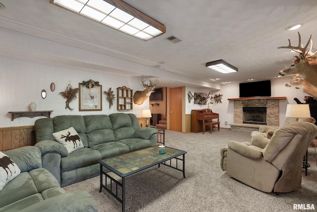 living room with visible vents, carpet, wooden walls, and a fireplace