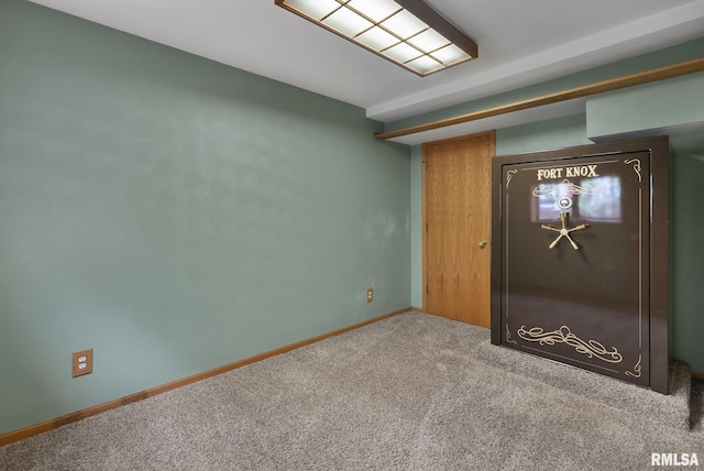 carpeted spare room featuring baseboards