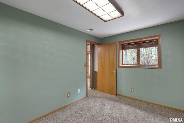 unfurnished room with carpet flooring, baseboards, and visible vents