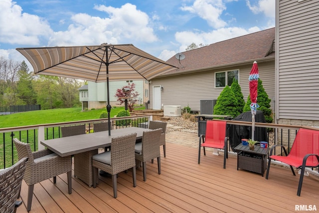 wooden deck featuring outdoor dining area and a yard