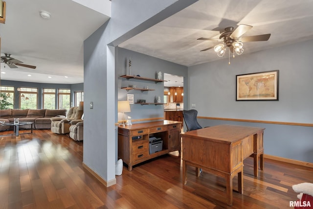 home office featuring baseboards, a ceiling fan, and dark wood finished floors