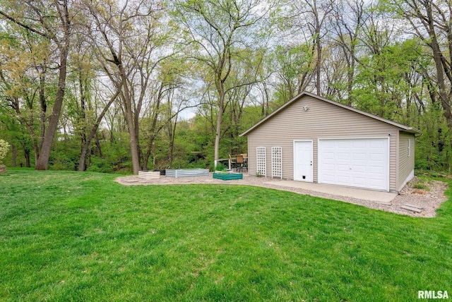 view of yard featuring a garage, an outbuilding, and a vegetable garden
