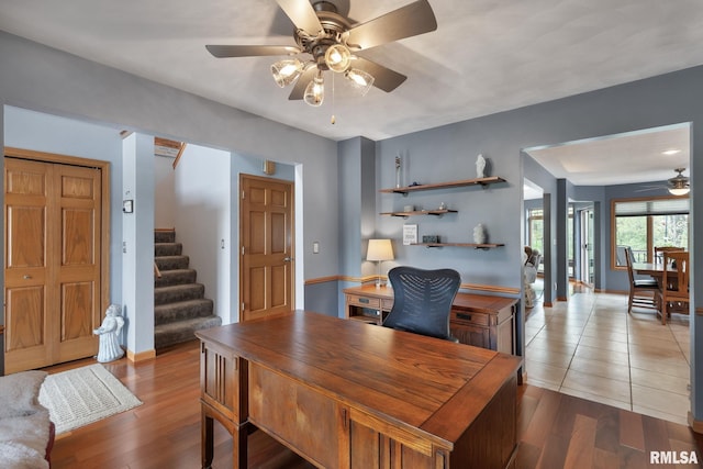 office space featuring baseboards, a ceiling fan, and wood finished floors