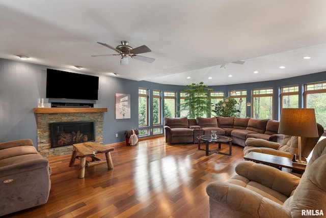 living area with ceiling fan, a stone fireplace, recessed lighting, baseboards, and wood finished floors