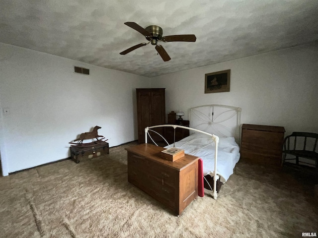 carpeted bedroom featuring a ceiling fan and visible vents
