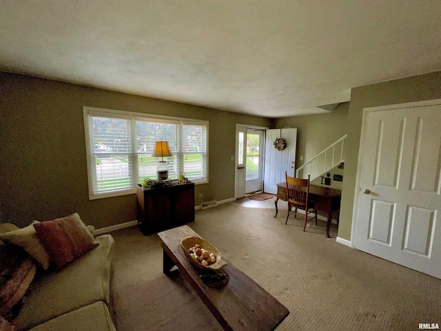 living area featuring baseboards, carpet flooring, stairs, and visible vents