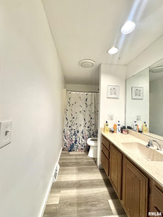bathroom featuring vanity, wood finished floors, toilet, baseboards, and a shower with curtain