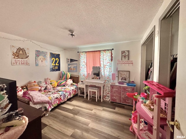 bedroom with a textured ceiling and wood finished floors