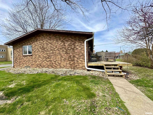 view of property exterior with a yard, brick siding, and a wooden deck