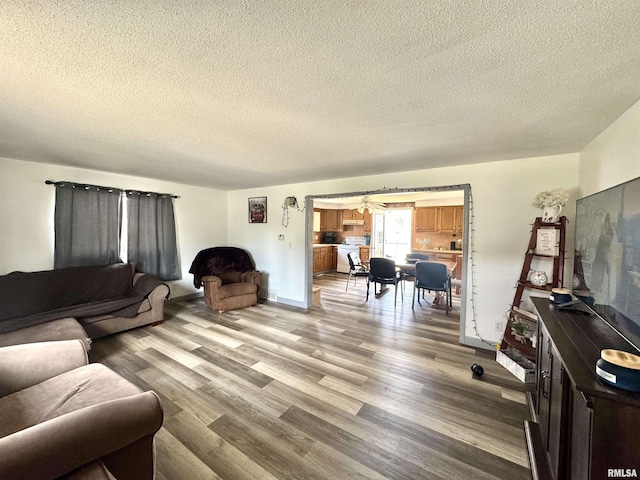 living area with light wood-type flooring and a textured ceiling