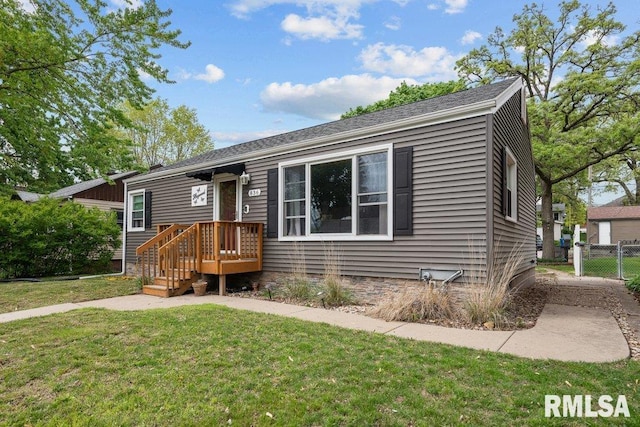 view of front of home featuring a front lawn and fence