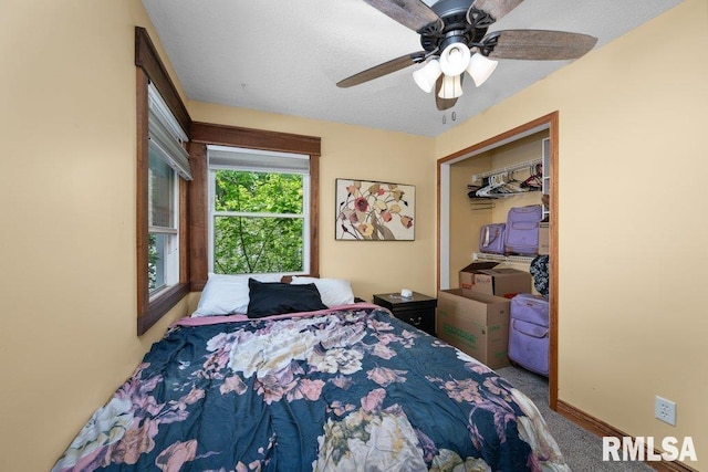 bedroom with a ceiling fan, a closet, carpet floors, a textured ceiling, and baseboards