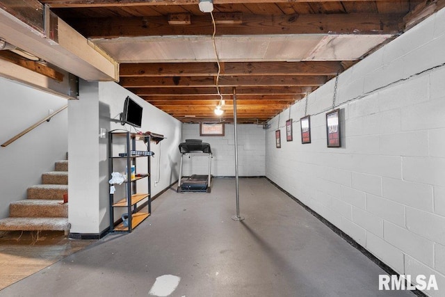 unfinished below grade area with stairs and concrete block wall