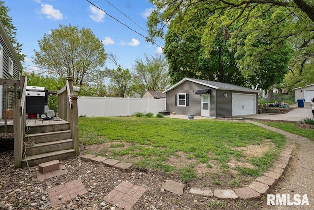 view of yard with a deck, an outdoor structure, a garage, and fence