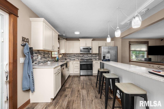 kitchen with tasteful backsplash, appliances with stainless steel finishes, plenty of natural light, and a kitchen bar