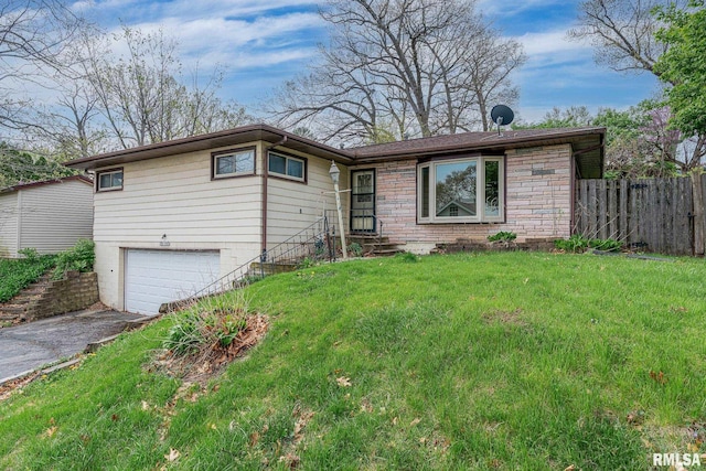 ranch-style home featuring driveway, fence, a garage, entry steps, and a front lawn