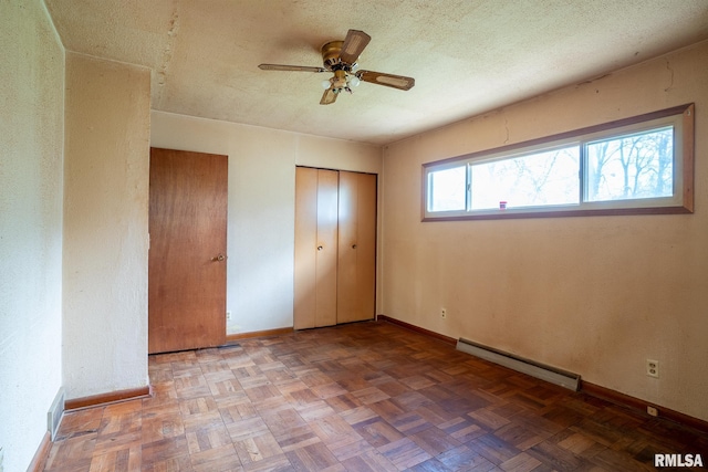 unfurnished bedroom featuring baseboards, a baseboard radiator, a ceiling fan, and a textured ceiling