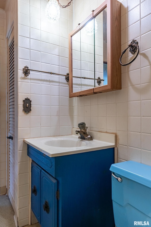 half bathroom featuring vanity, tile walls, decorative backsplash, and toilet