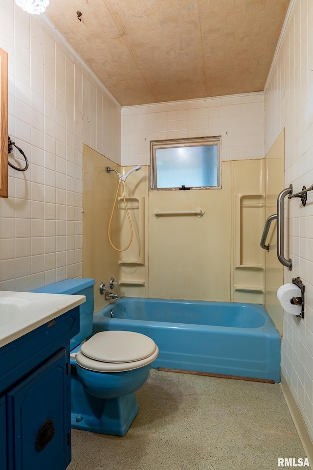 bathroom with tile walls, toilet, vanity, tub / shower combination, and speckled floor