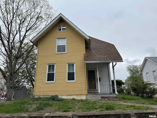 rear view of property featuring roof with shingles