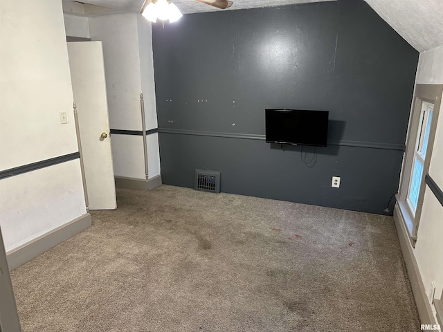 empty room featuring carpet flooring, a ceiling fan, and visible vents