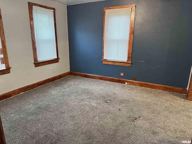 carpeted spare room with baseboards