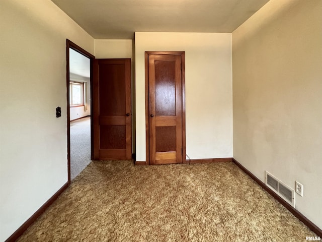carpeted empty room with baseboards and visible vents