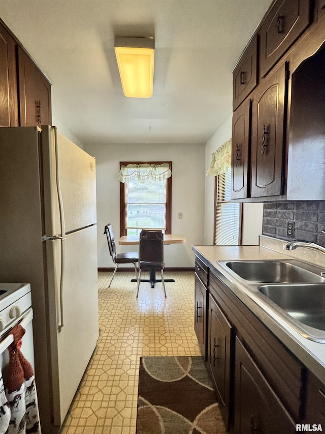 kitchen with light countertops, light floors, dark brown cabinets, and a sink