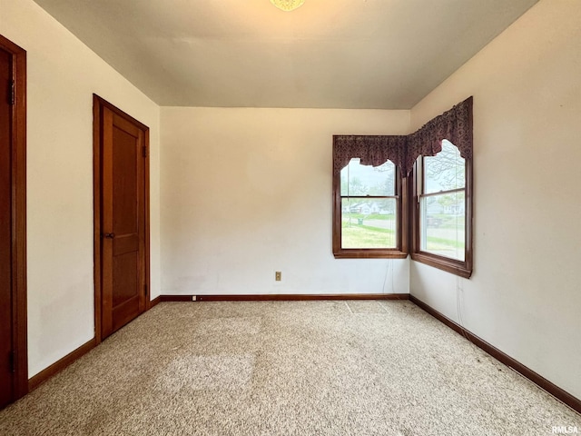 empty room with baseboards and light carpet