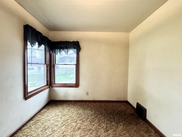 empty room featuring carpet floors and baseboards