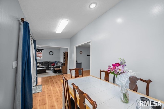 2303 Pinehurst St, Bettendorf, IA 52722 - dining area with light wood-style floors, lofted ceiling, and a textured ceiling