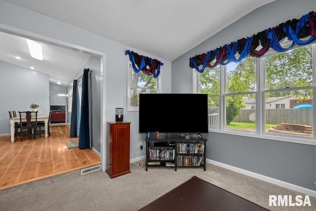 2303 Pinehurst St, Bettendorf, IA 52722 - carpeted living area featuring baseboards and vaulted ceiling