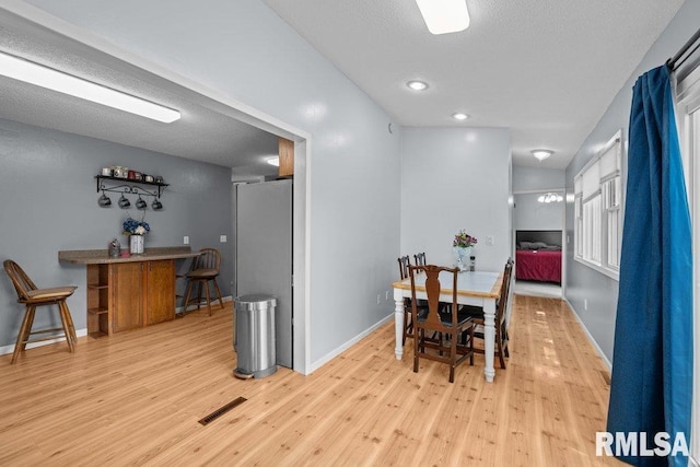 2303 Pinehurst St, Bettendorf, IA 52722 - dining area featuring wood finished floors, baseboards, and a textured ceiling