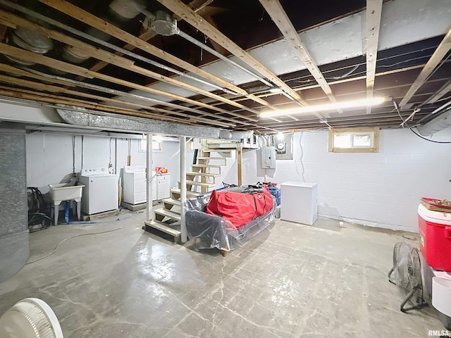 basement with refrigerator, a sink, electric panel, stairway, and independent washer and dryer