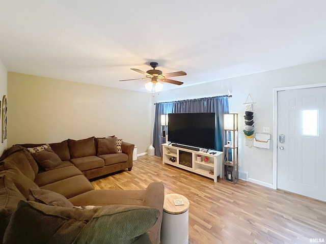 living room with light wood finished floors, visible vents, baseboards, and a ceiling fan