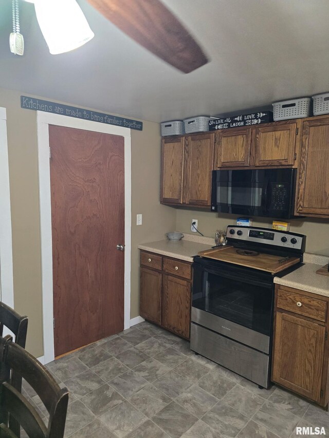 717 NE 2nd St, Galva, IL 61434 - kitchen featuring light countertops, electric range, brown cabinets, and black microwave