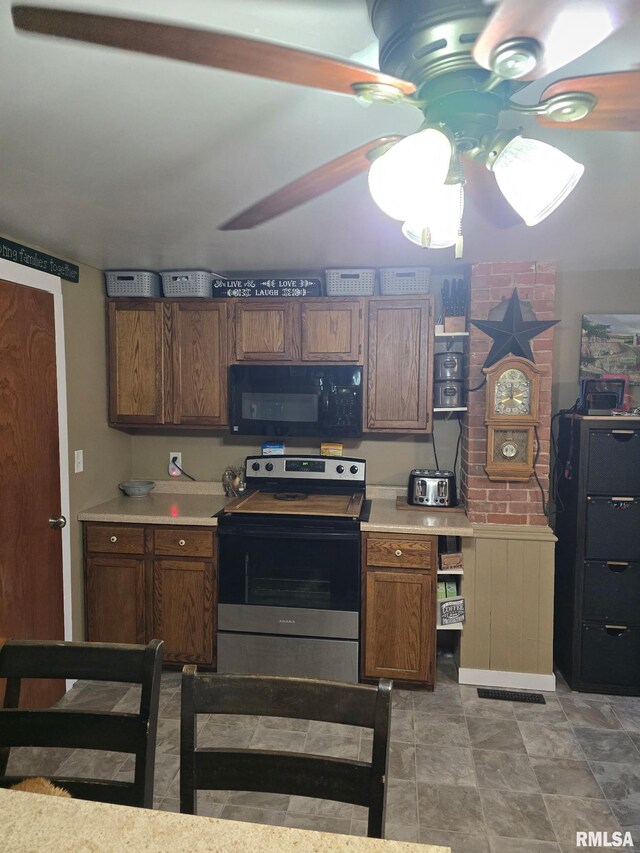717 NE 2nd St, Galva, IL 61434 - kitchen with light countertops, stainless steel electric range oven, ceiling fan, and black microwave