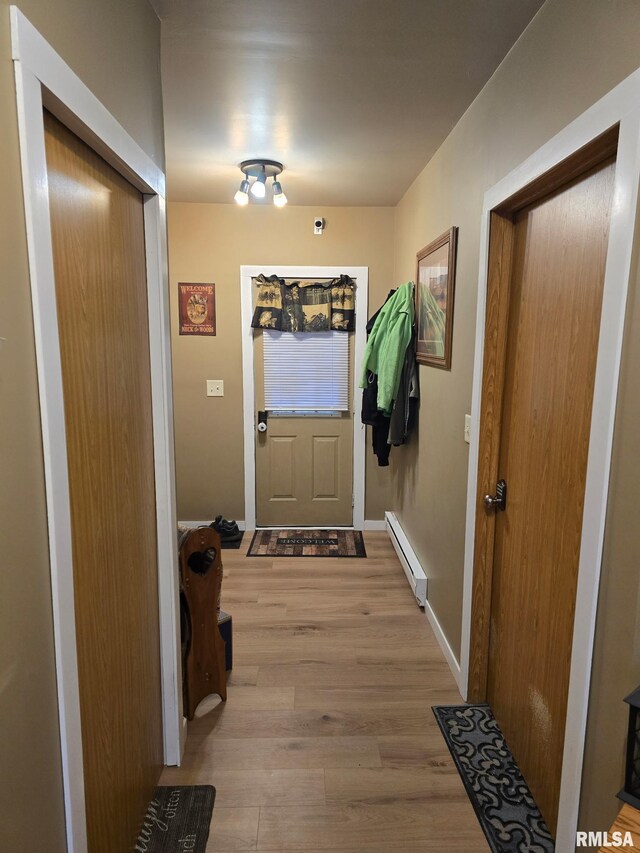 717 NE 2nd St, Galva, IL 61434 - doorway to outside featuring a baseboard heating unit and light wood-type flooring