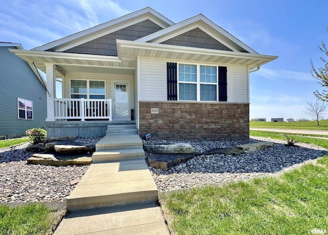 view of front of house with stone siding and a porch