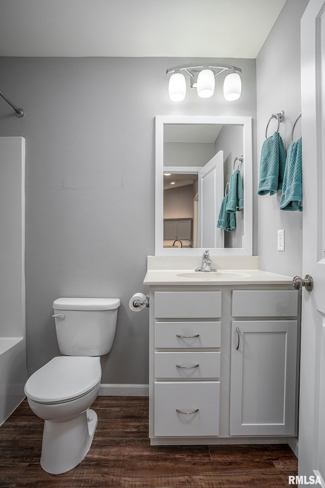 full bathroom featuring toilet, shower / bathtub combination, wood finished floors, vanity, and baseboards