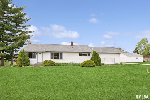 rear view of property with a chimney and a lawn