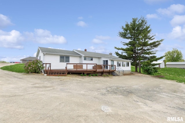 single story home featuring a chimney and a deck