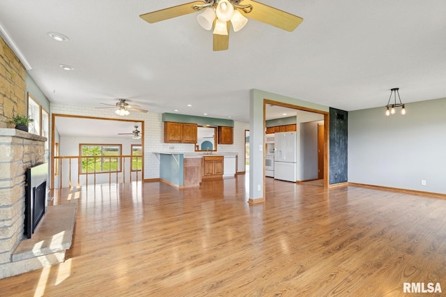 unfurnished living room featuring recessed lighting, light wood-style floors, a fireplace, and ceiling fan
