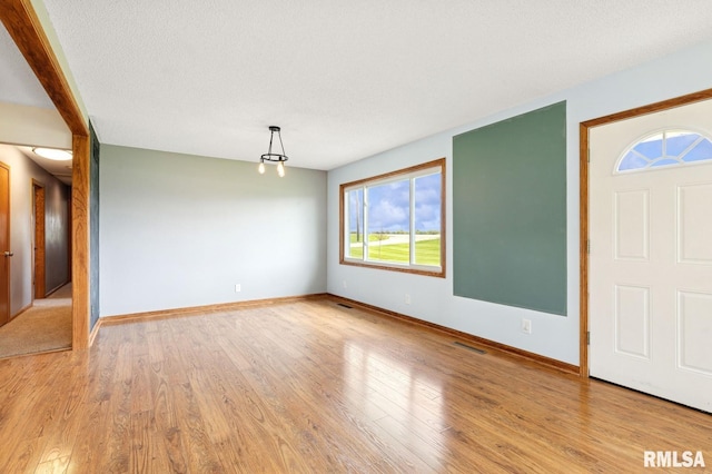 entryway featuring baseboards, visible vents, and light wood-type flooring