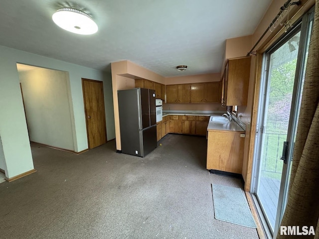 4528 5th St Unit B, East Moline, IL 61244 - kitchen with freestanding refrigerator, a sink, light countertops, brown cabinets, and oven